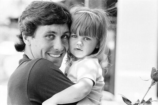 England footballer Kenny Sansom with his young daughter at the team base during the 1982