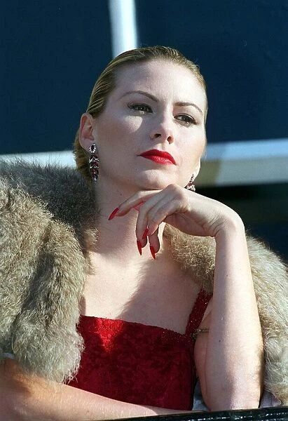 Evita Fashion Model on balcony wearing fur cape red dress long nails with red nail