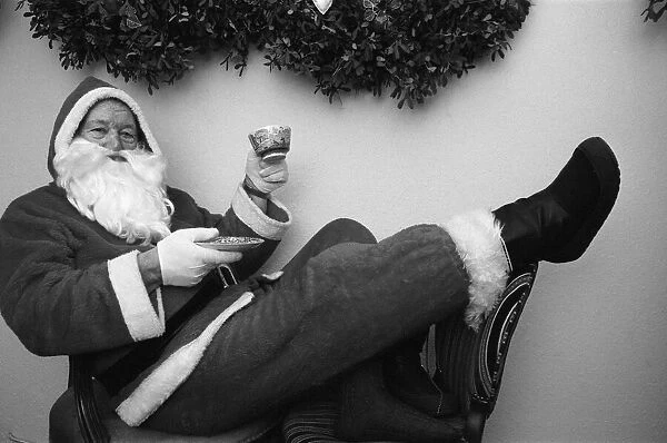 Father Christmas with a cup of tea in his grotto Birmingham. 23rd December 1988