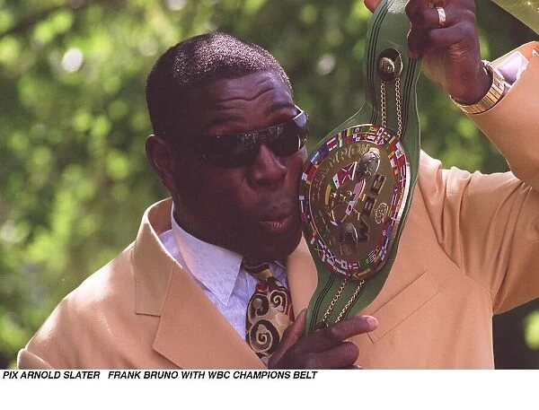 Frank Bruno holds up and kisses his WBC boxing championship belt the day after becoming