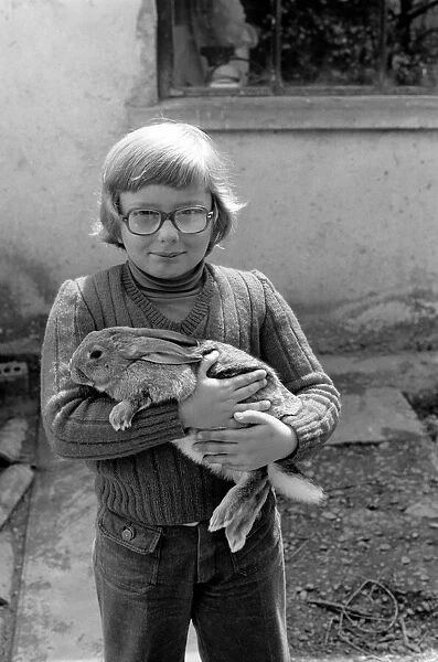 French schoolboy Jean Luc aged 8 with one of the families rabbits that will be due for