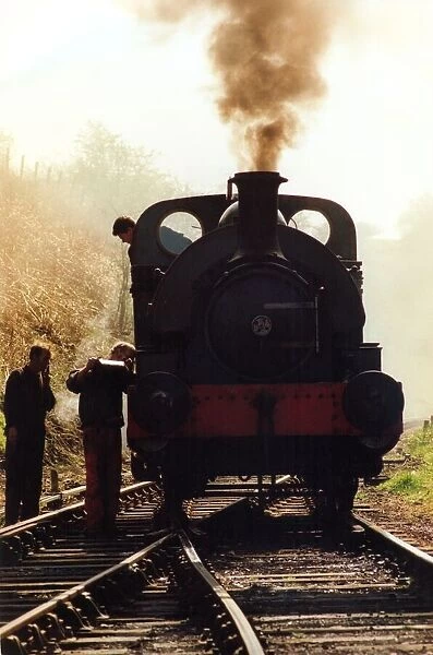 A general picture of a steam locomotive getting some attention from its engineer