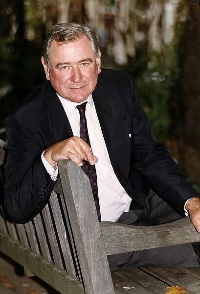 George Baker actor sitting on park bench
