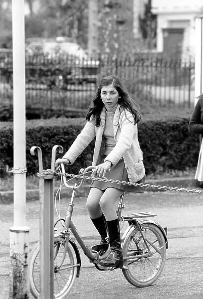 A girl riding her bike in a street in a French town April 1975 75-2072-016