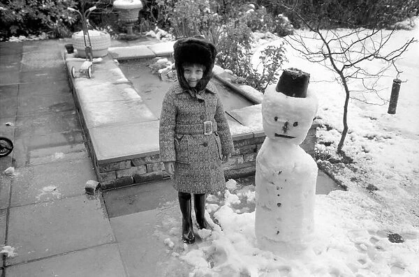 A girl with the snowman she built during the last fall of snow. March 1975 75-1706-012