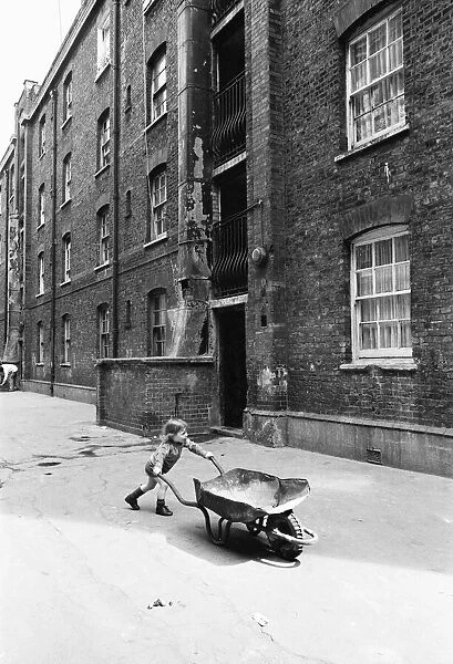 Two and a half year old Darren Haydn plays with his wheelbarrow outside the Great Eastern