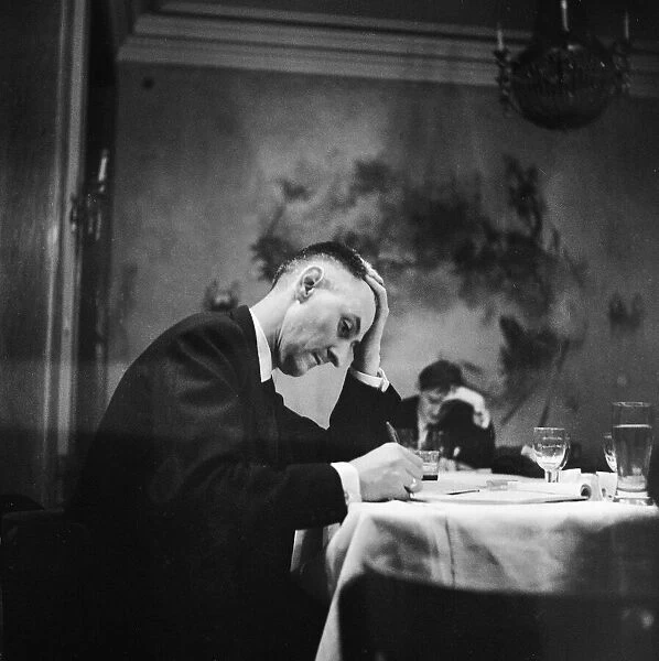 Hungarian Revolution. An unidentified Hungarian man writing at a table in a restaurant