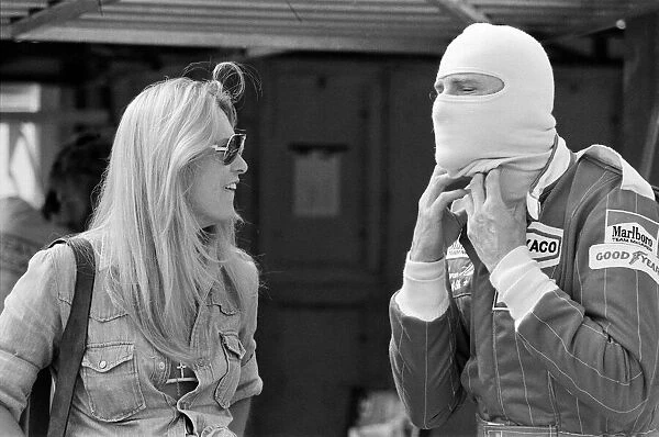 James Hunt talks to a female friend at a practice day for the British Grand Prix held at