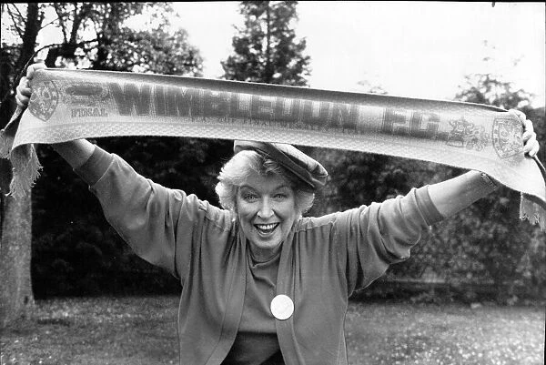 June Whitfield, actress and Wimbledon Football Club supporter holds the teams scarf aloft