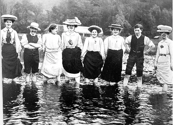 Lads and lasses plodging in a stream on a day out in everday wear