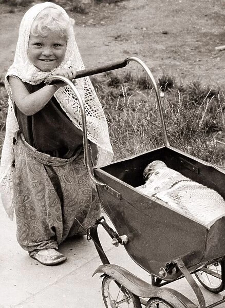 Little girl with doll pram, circa 1950