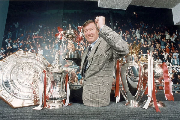 Manchester United manager Alex Ferguson posing with the trophies won in the 1993 - 1994