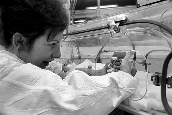 Medical. Mrs. Rosemary Letts holds baby Cara for the first time in the incubator at