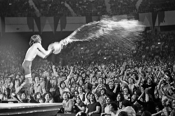 Mick Jagger throwing water over the crowd during a Rolling Stones performance at Earls
