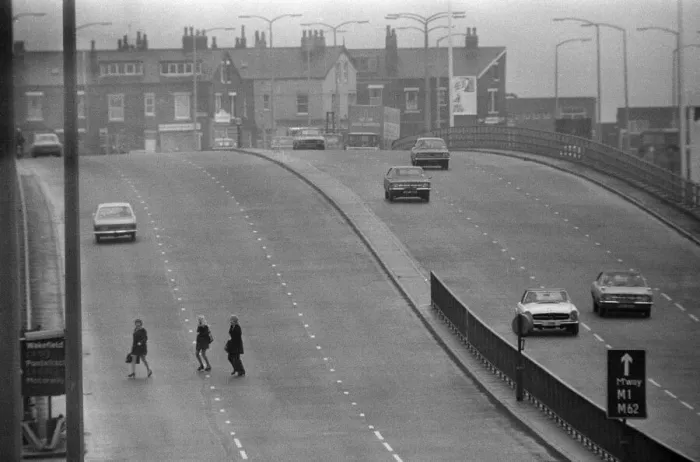 Framed Print : People crossing the motorway dangerously, in a black and white print Framed Print : People crossing the motorway dangerously, in a black and white print