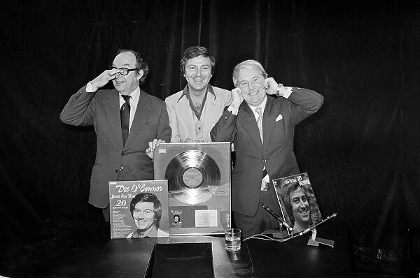 Morecambe and Wise present Des O Connor with a golden disc to mark 100000 sales of
