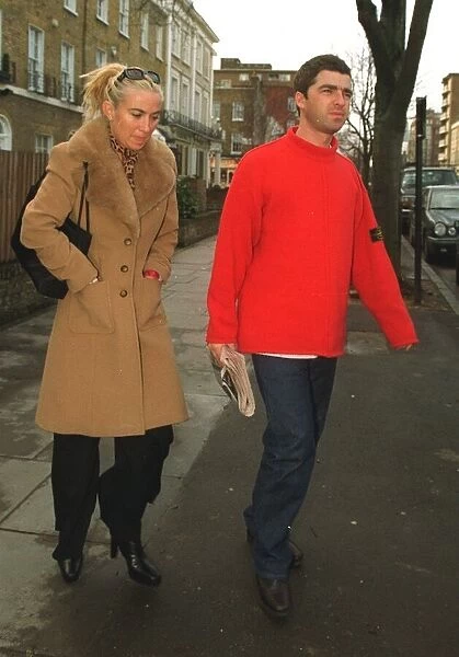 Noel Gallagher of Oasis holding a copy of the Daily Mirror newspaper with his girlfriend