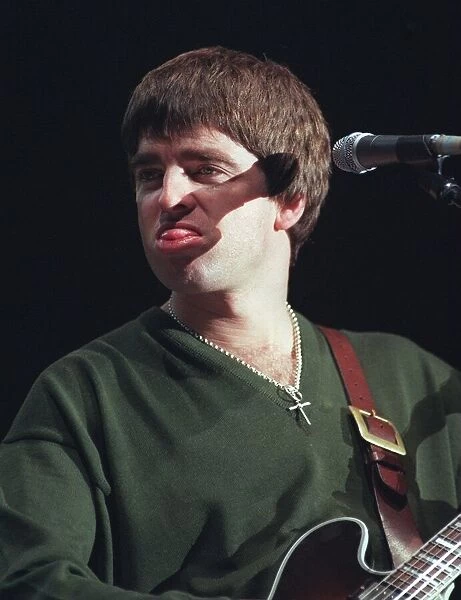 Noel Gallagher Oasis pop group December 1997 Sticking tongue out playing guitar