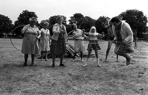 Pensioners playing with Hula Hoops in park August 1976