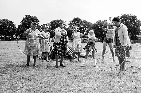 Pensioners playing with Hula Hoops in a Twickenham park, London. August 1976 P76 734