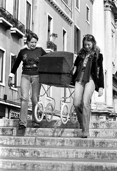 People: Culture: General scenes in Venice. A couple of young women carry a pram over one