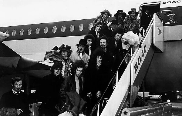 Pop groups including The Jimi Hendrix Experience and The Byrds standing outside aeroplane