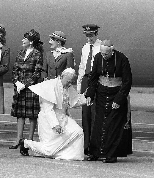 Pope John Paul II at Cardiff airport on his visit to Wales kneels down to kiss the ground