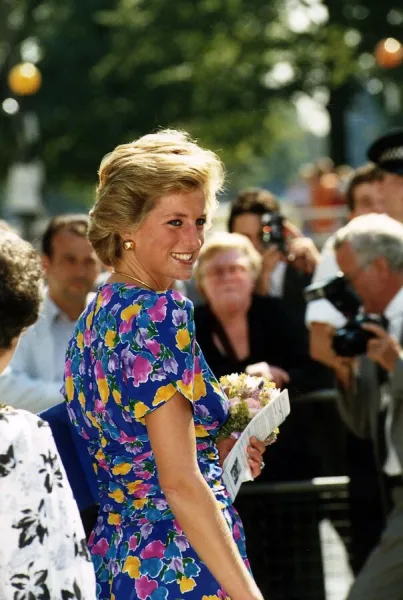 Princess Diana in blue dress with flower pattern holding bouquet of flowers 19th