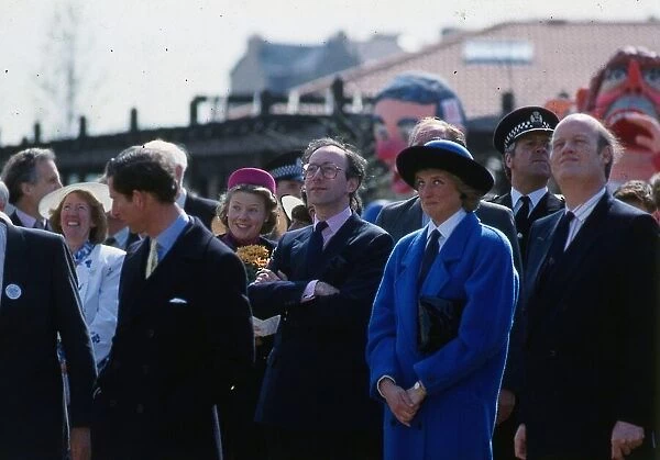 Princess Diana, Princess of Wales, wearing a blue coat, watching the Coca Cola ride with