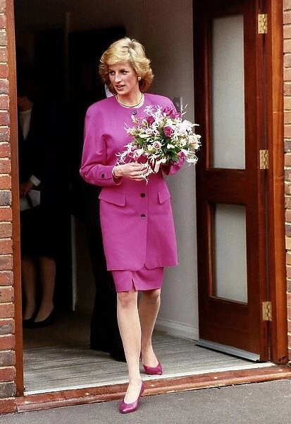 Princess Diana wearing pink suit holding bunch of flowers. Circa 1989