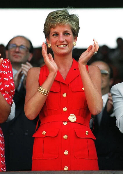 Princess Diana, wearing red sleveless dress, applauds the play at the Wimbledon mens