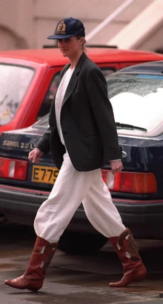 Princess Diana wearing an unusual combination of white trousers, boots