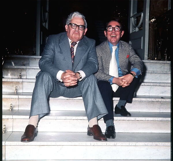 Ronnie Barker with Ronnie Corbett sitting on the steps outside the building