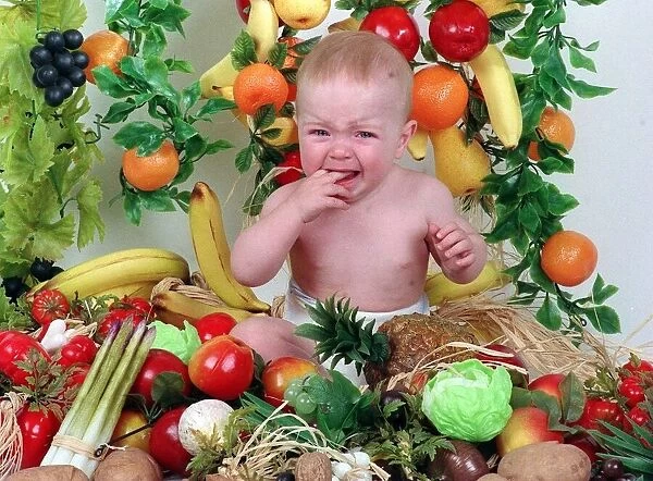 Sam Stewart baby wearing nappy surrounded by fruit and vegetables September 1992 fingers