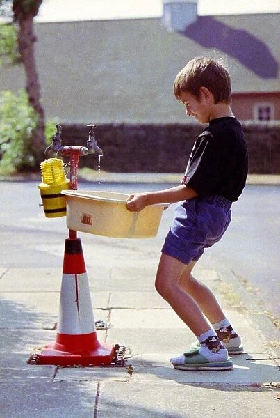 Sandpipes in Bradford - a boy fills a bucket full of water from an outside tap