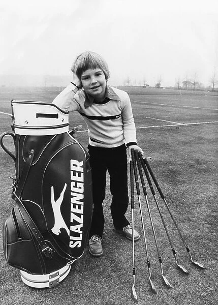 Seven year old Charles Casson stands with his specially made scaled down clubs made for
