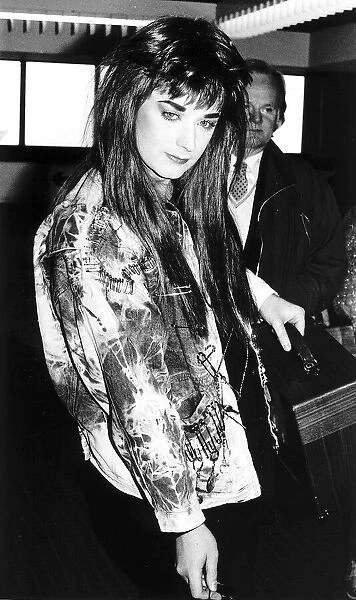 Singer Boy George wearing a long wig and a coat covered with safety pins