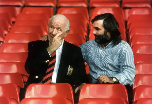 SIR MATT BUSBY AND GEORGE BEST SEATED IN FOOTBALL STANDS OF #21877402