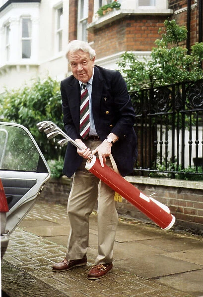 Sir Nicholas Scott MP holding golf clubs