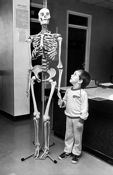 A small child holding hands with a skeleton on 10th September 1985