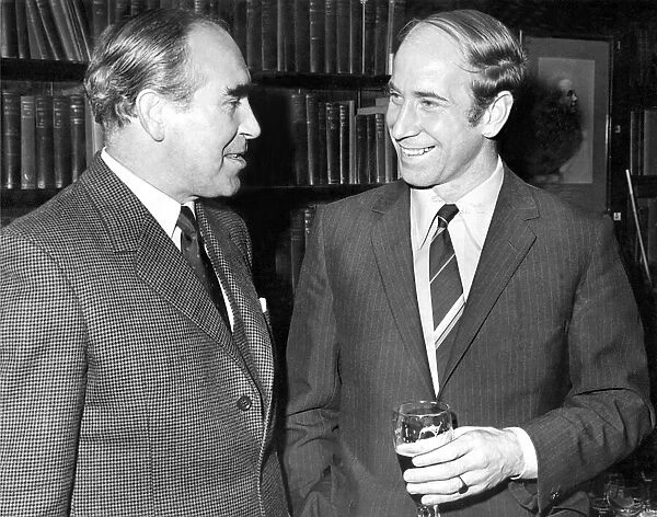 A smiling Bobby Charlton talking to England team manager Sir Alf Ramsey (left