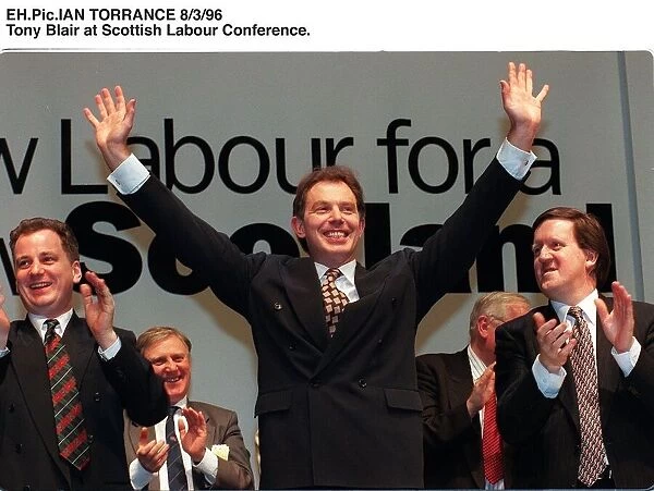 Tony Blair arms in the air looking triumphant, receiving applause