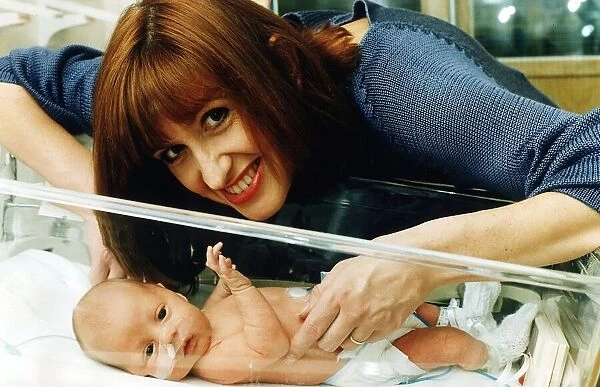 TV presenter Jackie Bird holding her baby March 1995