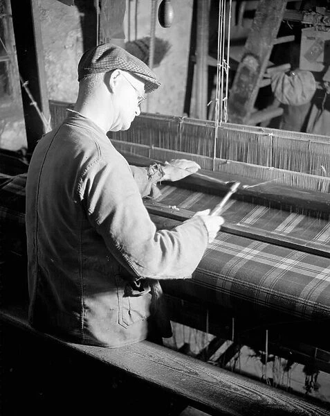 Willie Meisle using a loom to weave a tartan. Circa 1930
