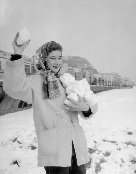 A woman having a snowball fight with her friend on Hastings beach. 8th March 1955