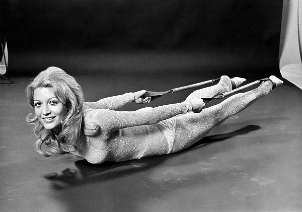 Woman lying on the floor doing slimming exercises. January 1971