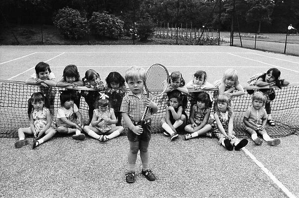 Three year old Daniel Jarmin holds a tennis racket as he poses with other friends in his
