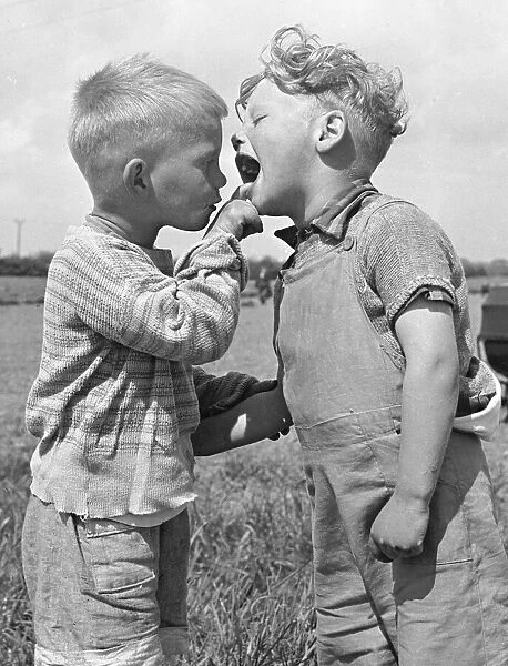 Four year old Keith Mackevitt (right) has his mouth checked by his friend Michael King