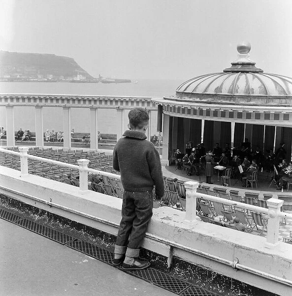 A young boy watching a band playing in the bandstand at Scarborough, North Yorkshire