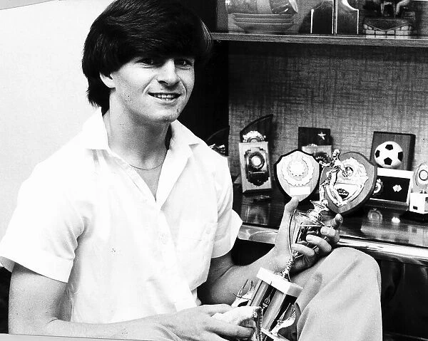 A young Charlie Nicholas Celtic football player with trophies